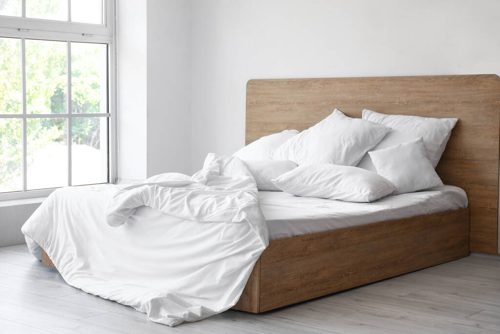 轻便卧室的内部，舒适的双人床和白色枕头图片
