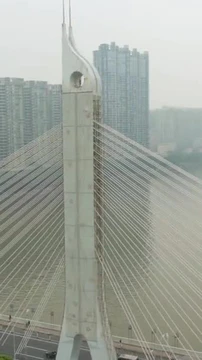 广州市的桥在烟雾中,车流汹涌.广东，中国。空中景观。无人机是逆时针飞行的垂直录像图片
