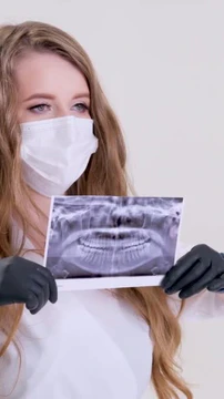 牙医手中人类下巴的X光全景人牙的X光照片。牙科医生在他的手上拿着一副黄色医疗手套牙医外科的X光全景照片。高质量的图片