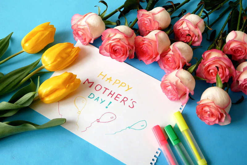 母亲节快乐，有一束美丽的黄色和红色的郁金香，玫瑰和蓝色背景的贺卡，特写