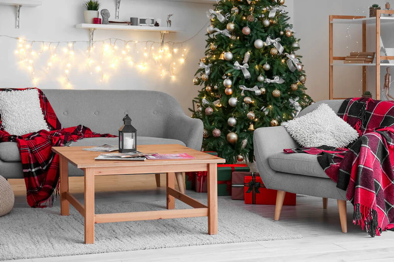 客厅的内部，有明亮的圣诞树、沙发和扶手椅