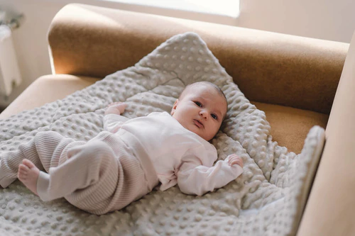 Portrait of a 1 month old baby. Cute newborn baby lying on a developing rug. Love baby. Newborn baby and mother.图片