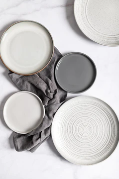 平铺着纹理波纹的空灰色陶瓷盘，灰色背景上有餐巾纸图片