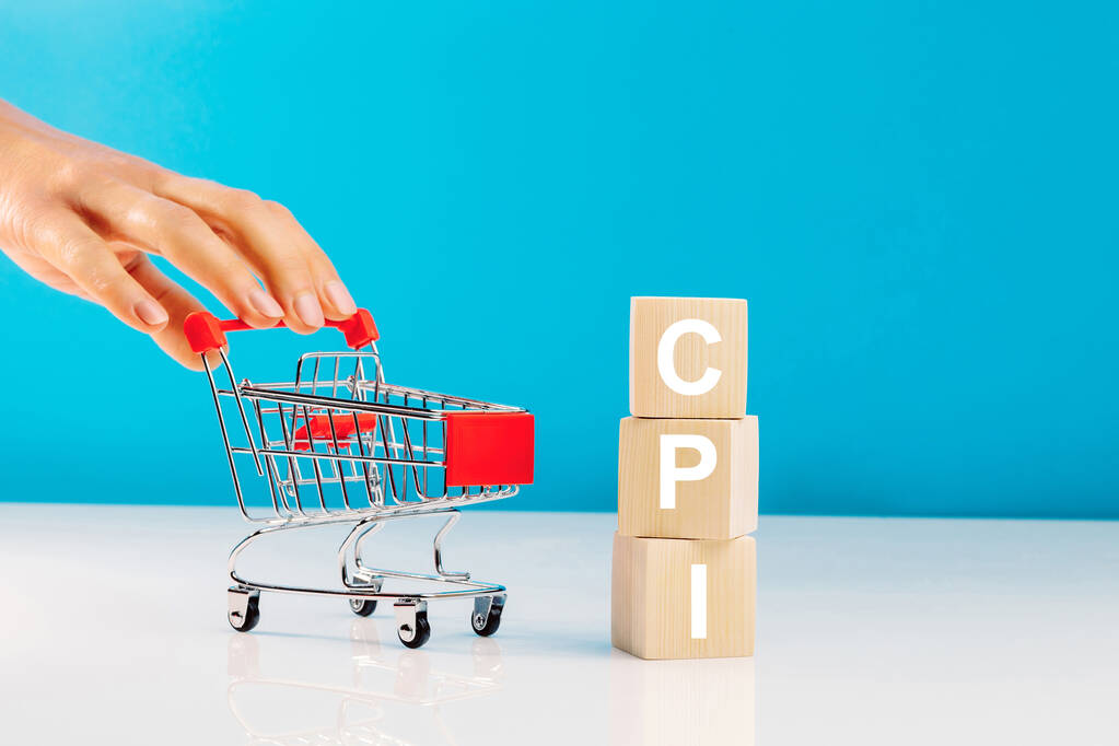 消费者价格指数（CPI）- -消费者价格指数（CPI）的符号。消费者价格指数（CPI）一字不漏的缩写消费者价格指数（CPI）和女人的手推着蓝色背景的空购物车。商业和消费物价指数、消费物价指数概念图片