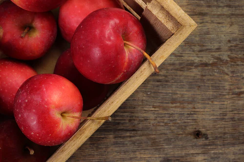 小红秋草莓形苹果切片种子，装在木箱中，以乡村木箱为背景  图片