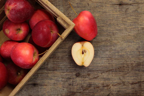 小红秋草莓形苹果切片种子，装在木箱中，以乡村木箱为背景  图片