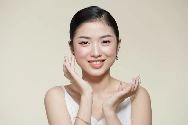 微笑的亚洲女人摸着健康的皮肤肖像