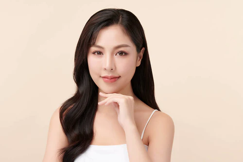美丽的年轻亚洲女人，有着米色背景、面部护理、面部治疗、美容、美容美发、水疗、亚洲女性肖像等洁白新鲜的肌肤.图片