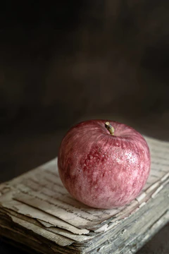 "一个成熟的苹果在一本书的背景."图片